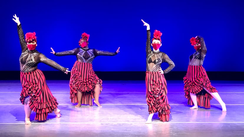 Bold dancers in striped costumes at California State University performance event.