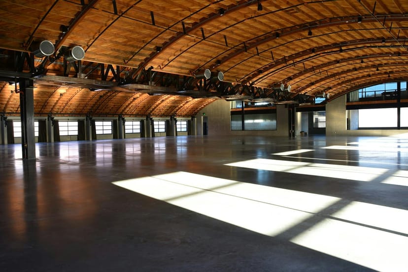 Spacious event venue with vaulted wooden ceiling, ideal for meetings and gatherings