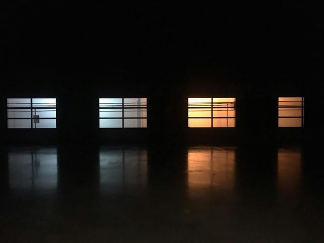 Versatile event venue with tinted blue and orange windows, ideal for networking and art events.