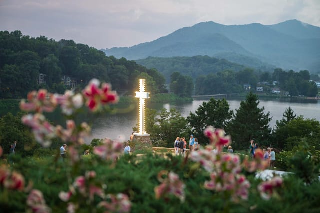 Outdoor spiritual retreat venue at Power of Love Fellowship with illuminated cross and tranquil nature.