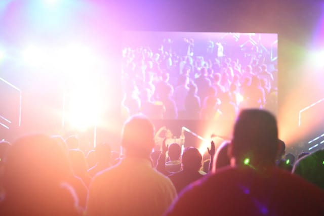 Vibrant EPIC LIVE LOUNGE event with dynamic lighting and engaging video screen.