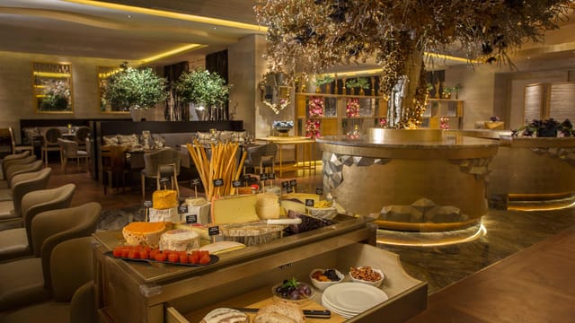 Elegant dining at il Mare, Hotel Mulia with inviting ambiance and gourmet food display.