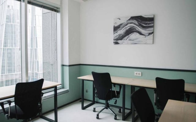 Minimalist co-working space in Menara Mandiri with ergonomic chairs, ideal for meetings.