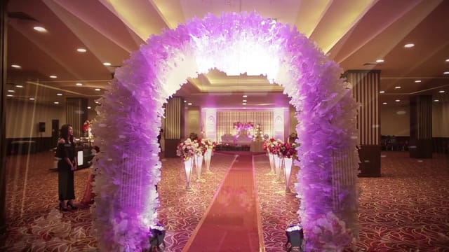 Elegant Crystal Ballroom with floral arch and purple lighting for wedding events.