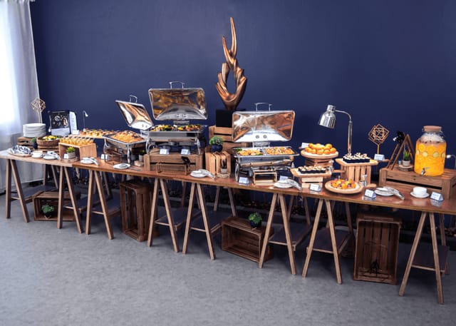 Event planner with buffet setup for corporate event featuring rustic food stations.