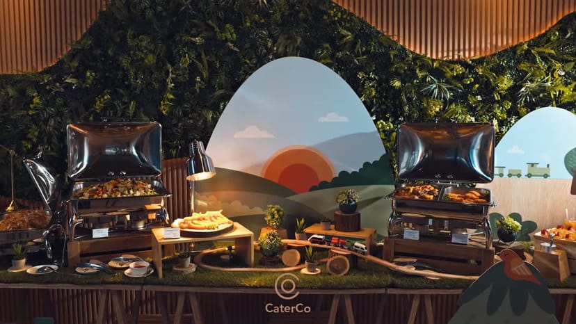 Elegant buffet setup by Event Planner at CaterCo, featuring lush greenery and warm lighting.