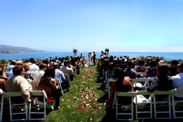 Outdoor wedding ceremony at Terranea Resort with ocean backdrop and floral pathway.