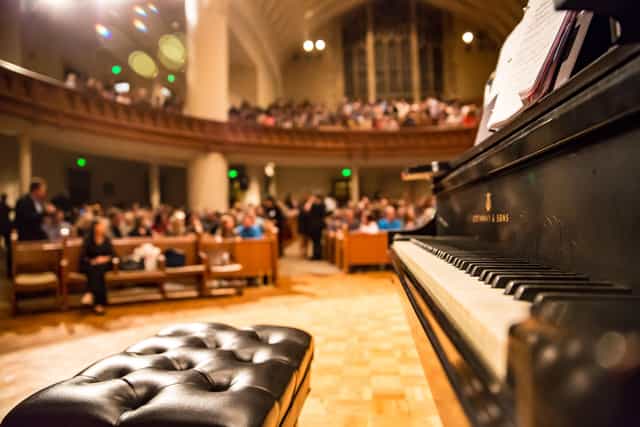 Elegant auditorium foyer with grand piano, perfect for concerts and recitals.