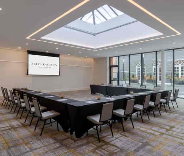 "Spacious corporate meeting room with U-shaped table and natural light at The Darcy"