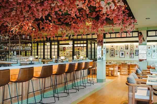 Vibrant brunch restaurant with floral installation, ideal for events and gatherings.