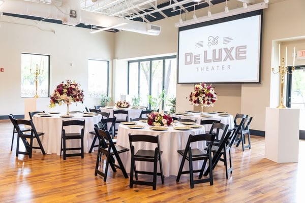 DeLUXE Theater event space with elegant round tables, ideal for corporate gatherings.