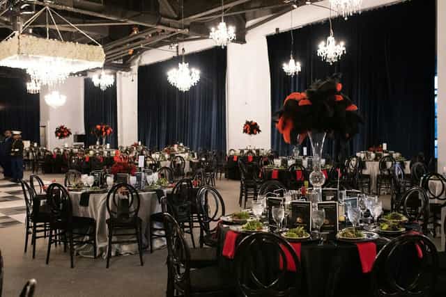 Elegant gala event space with dark linens and bold centerpieces at Bayou Place.