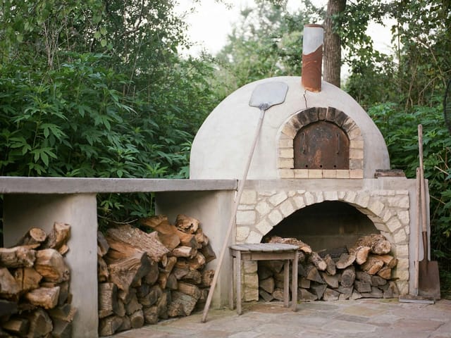 Rustic outdoor pizza oven in Blackwood Living for unique cooking classes and events.