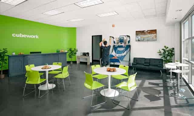 Modern event space with bright green wall, ideal for casual meetings and team-building activities.