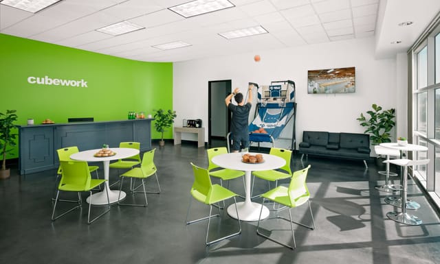Modern event space with bright green wall, ideal for casual meetings and team-building activities.