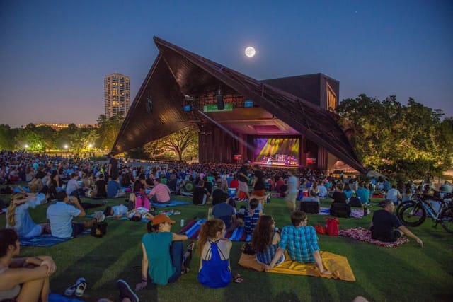 Main Stage at Miller Outdoor Theatre, vibrant outdoor concert venue with a twilight sky.