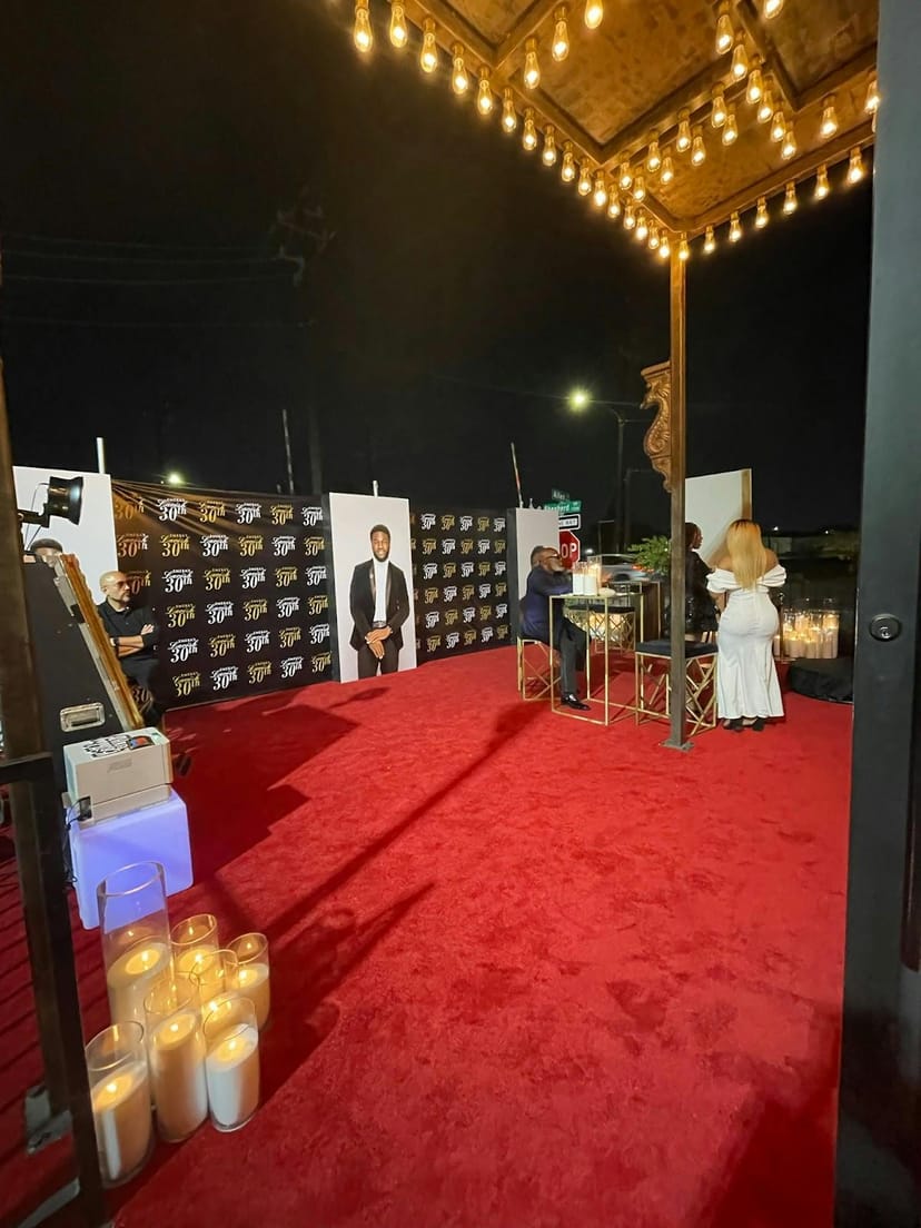 Stylish outdoor event space with a red carpet and elegant decor for networking and photos.