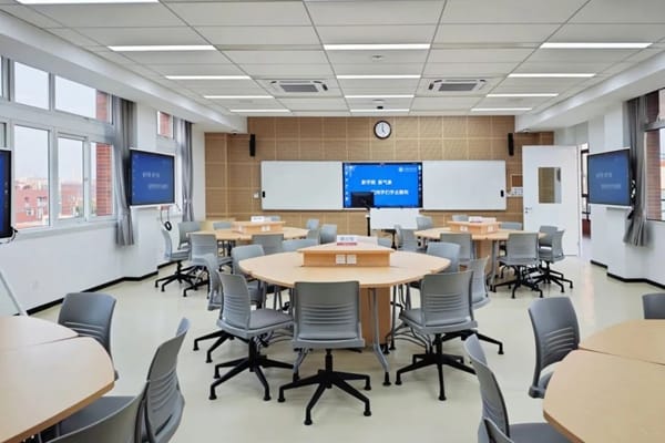 Modern classroom in Shanghai University with round tables for collaborative workshops.