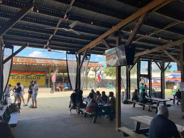 Beer garden at Karbach Brewing Co. with shaded seating, ideal for gatherings and networking.
