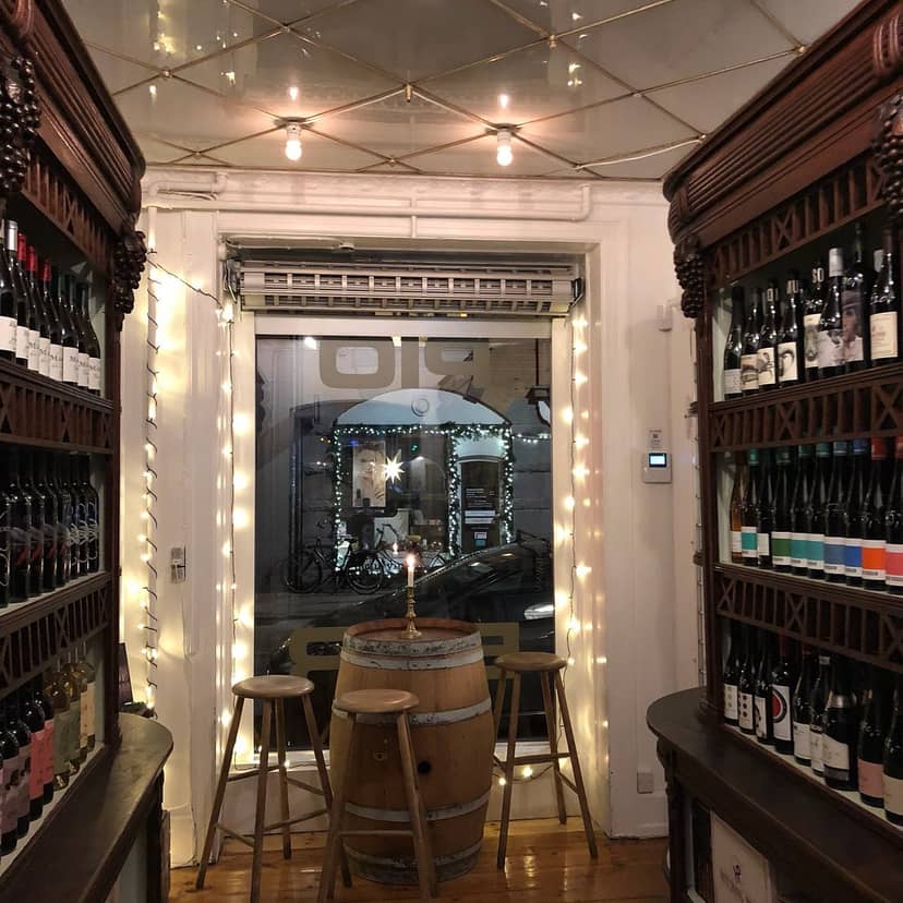 Cozy wine bar in Bar'Vin with shelves of bottles, perfect for tastings and private events.