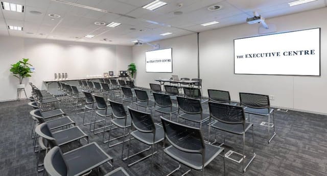 Modern event space with dual screens for corporate meetings and seminars.
