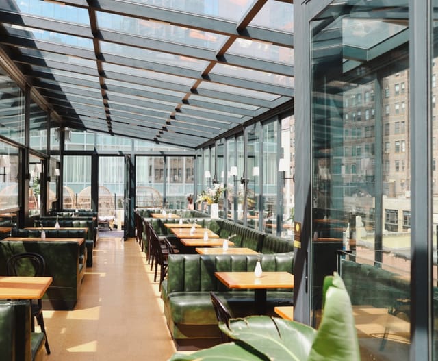 Modern airy restaurant with glass walls, perfect for events and gatherings.