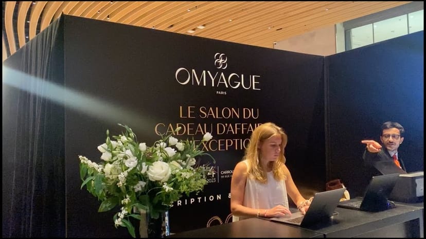 Sleek registration setup at Salon Omyague for upscale event, featuring elegant floral arrangement.