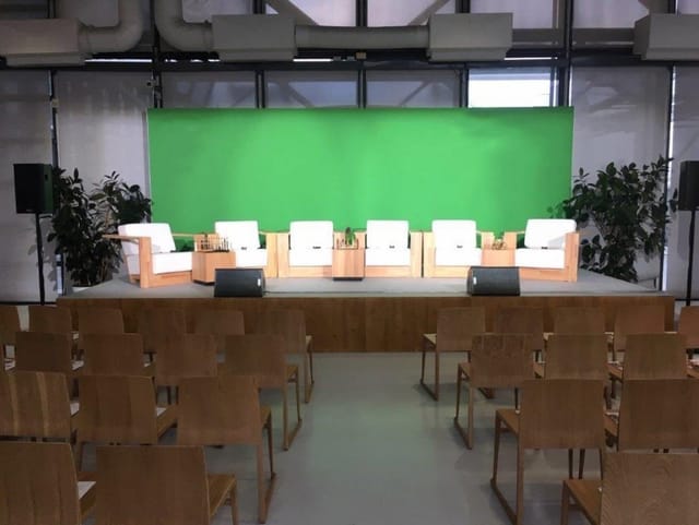 Espace U at Centre Pompidou, modern panel discussion setup with green screen backdrop.