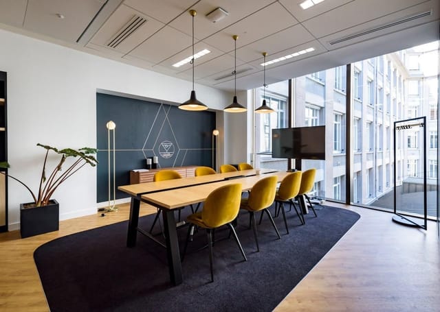 Modern meeting room at Espace Pierre Cardin with yellow chairs for workshops and planning.
