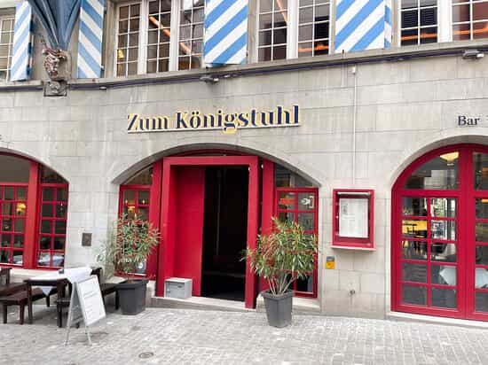 Charming entrance of Zum Königstuhl restaurant with red doors, ideal for events and meetings.