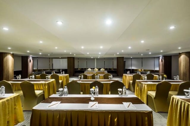 Meeting room at The Nest Hotel with gold tablecloths, ideal for conferences and workshops.