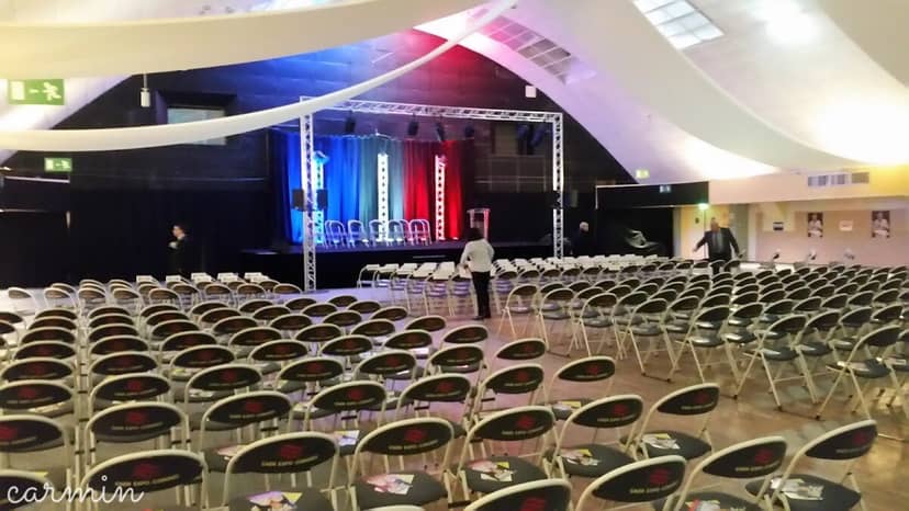 Amphithéâtre Caliste setup for conference with organized seating and vibrant stage backdrop.