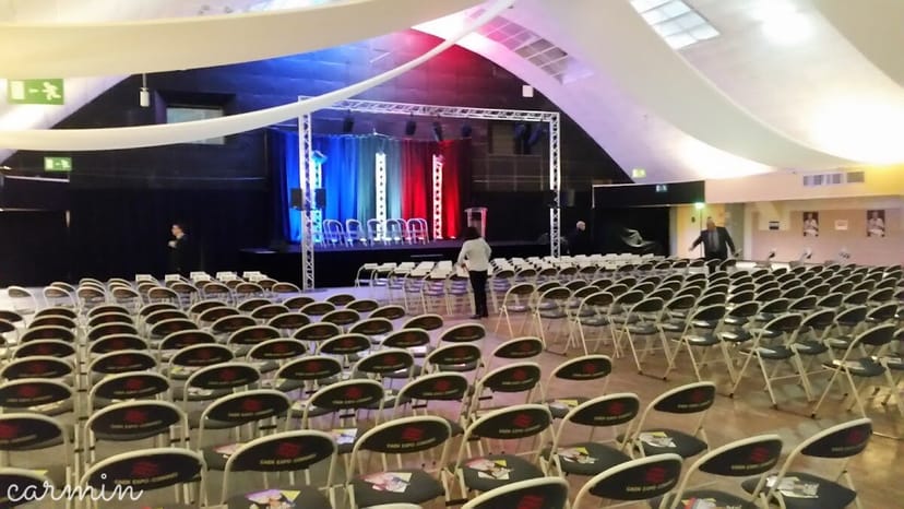 Amphithéâtre Caliste setup for conference with organized seating and vibrant stage backdrop.