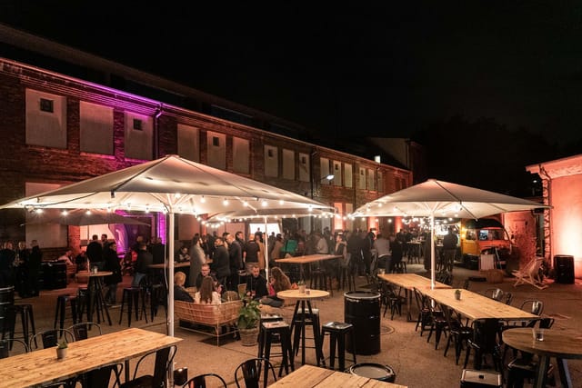 Outdoor event space at Motorwerk Berlin with warm lighting for networking and social gatherings.