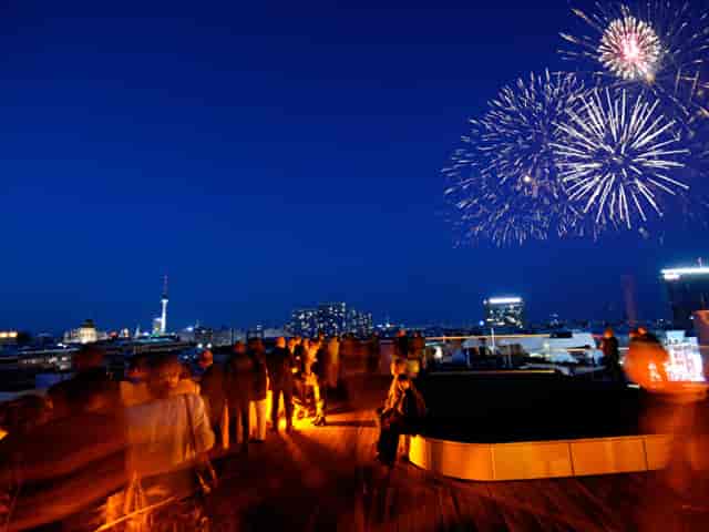 Rooftop event at ewerk Berlin with cityscape and fireworks, perfect for celebrations.