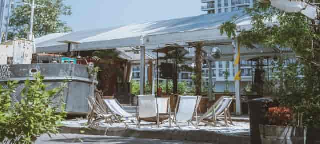 Outdoor event space at SAGE Berlin with tent, lounge chairs, and greenery for gatherings.