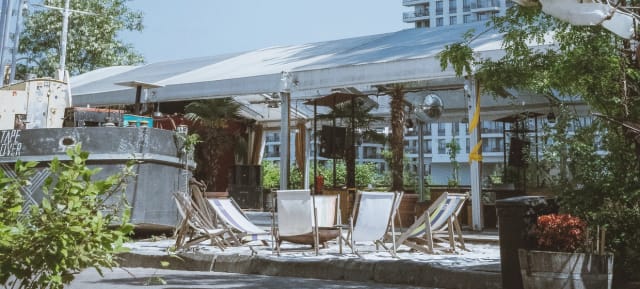 Outdoor event space at SAGE Berlin with tent, lounge chairs, and greenery for gatherings.