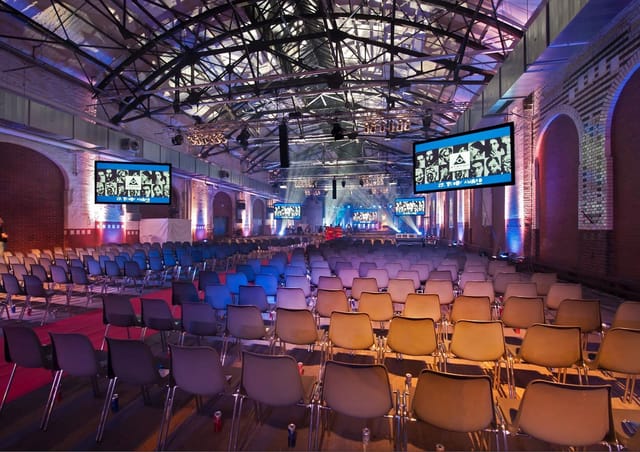Symposium in STATION-Berlin: spacious event venue with industrial decor for conferences.