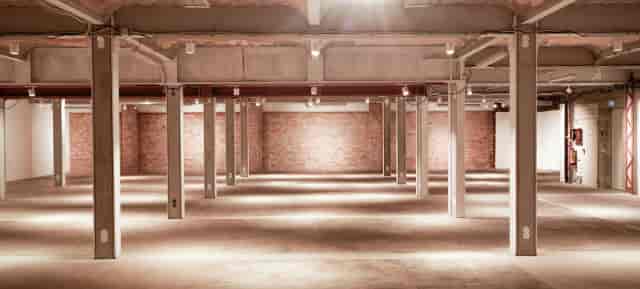 Spacious industrial venue with exposed brick, perfect for corporate events or social gatherings.
