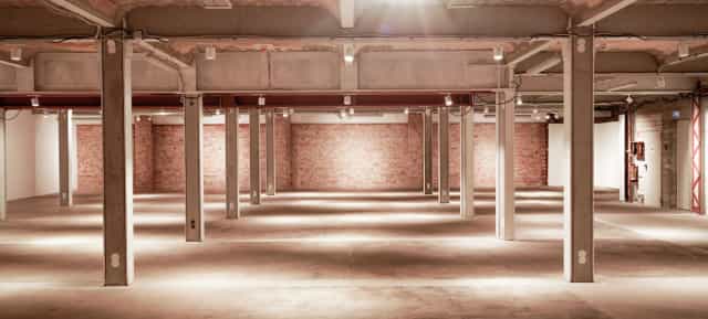 Spacious industrial venue with exposed brick, perfect for corporate events or social gatherings.