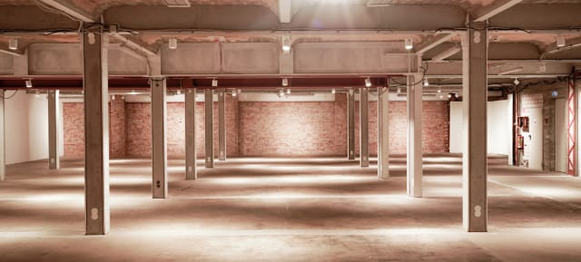Spacious industrial venue with exposed brick, perfect for corporate events or social gatherings.