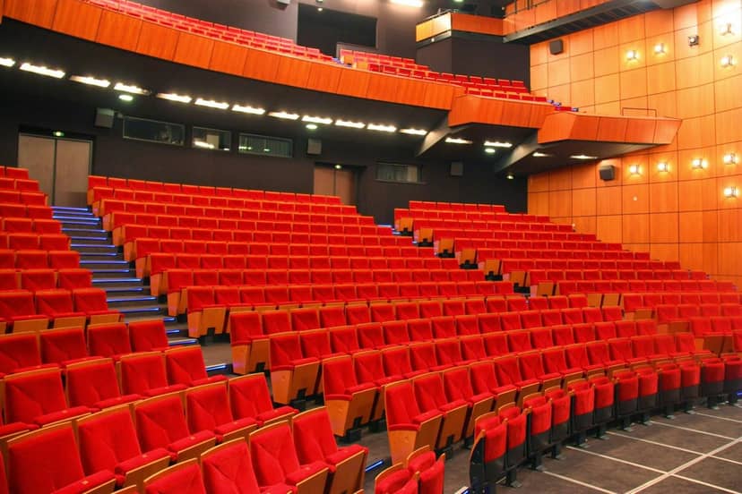 Auditorium with vibrant red seating in Salle Segonzac, ideal for conferences and performances.