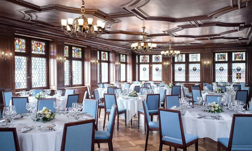 Elegant banquet hall with round tables, stained glass, ideal for formal dinners and events.