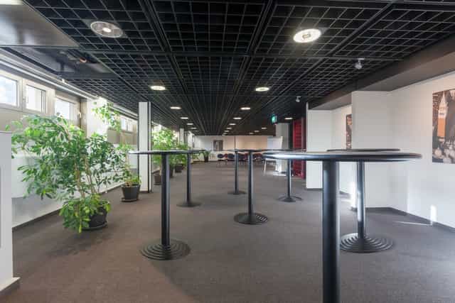 Spacious Seminar Room Venezia with tall tables for networking events and receptions.