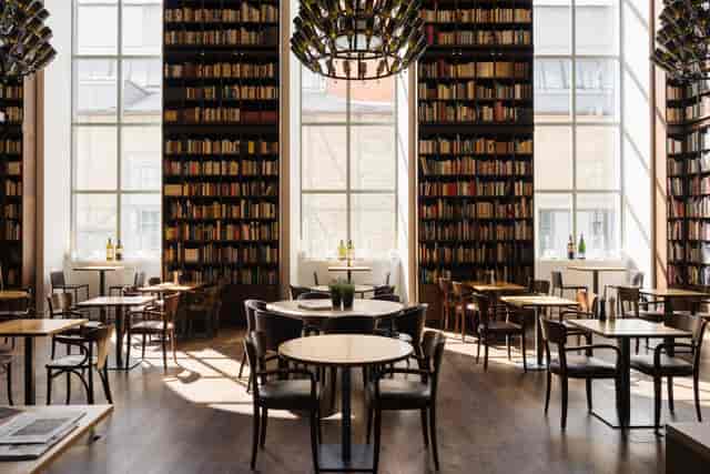 Stylish B2 Hotel meeting room with natural light, ideal for workshops and networking events.