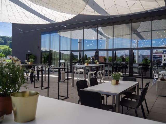 Stylish outdoor event space with modern furnishings and greenery for gatherings.