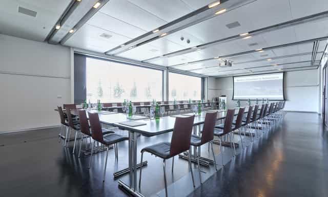 Modern meeting room in ACE Zurich with a long table, perfect for corporate workshops.