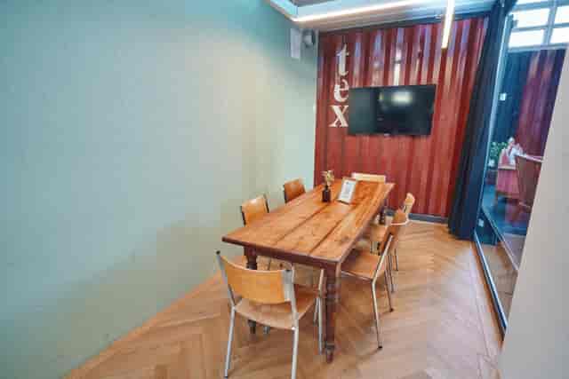 Cozy K1 meeting space in ACE Zurich, featuring wooden table and natural light for workshops.