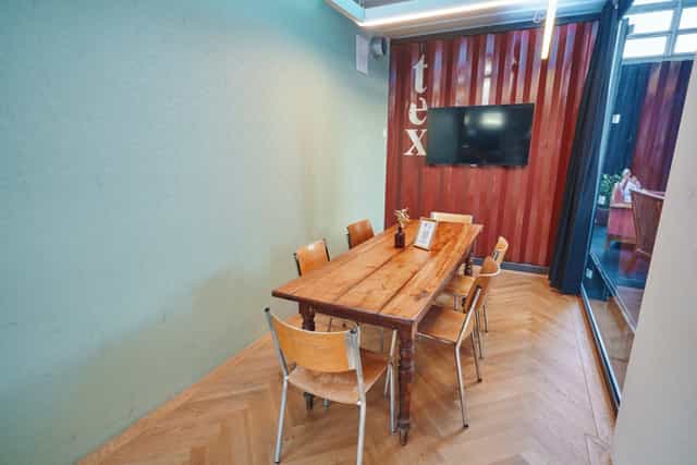 Cozy K1 meeting space in ACE Zurich, featuring wooden table and natural light for workshops.