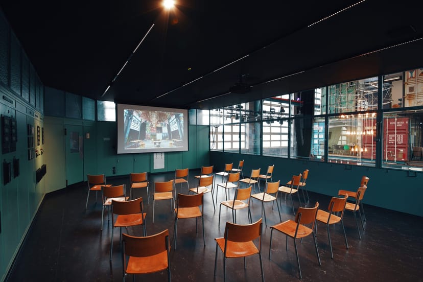 Flexible meeting space at Kraftwerk, featuring a large screen for workshops and brainstorming.